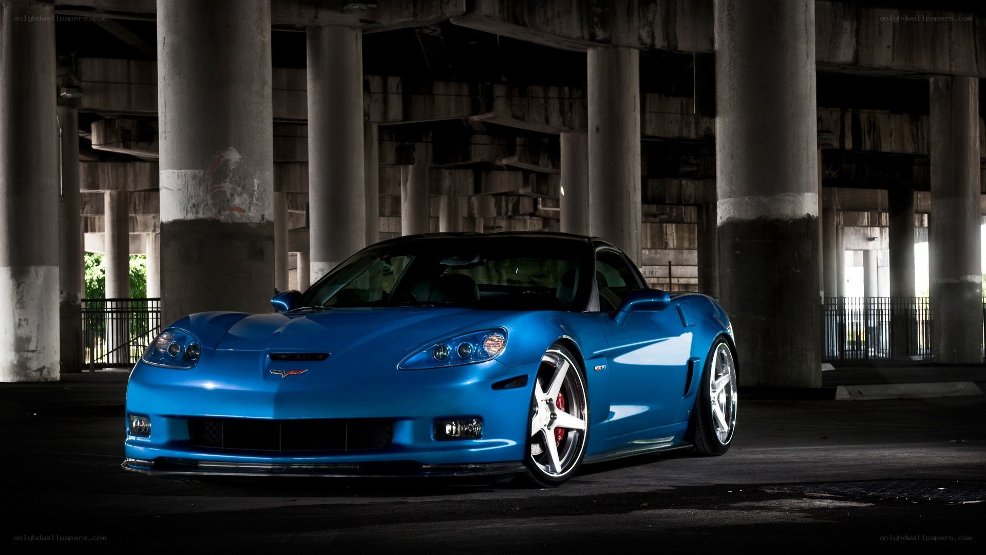 blue corvette under bridge