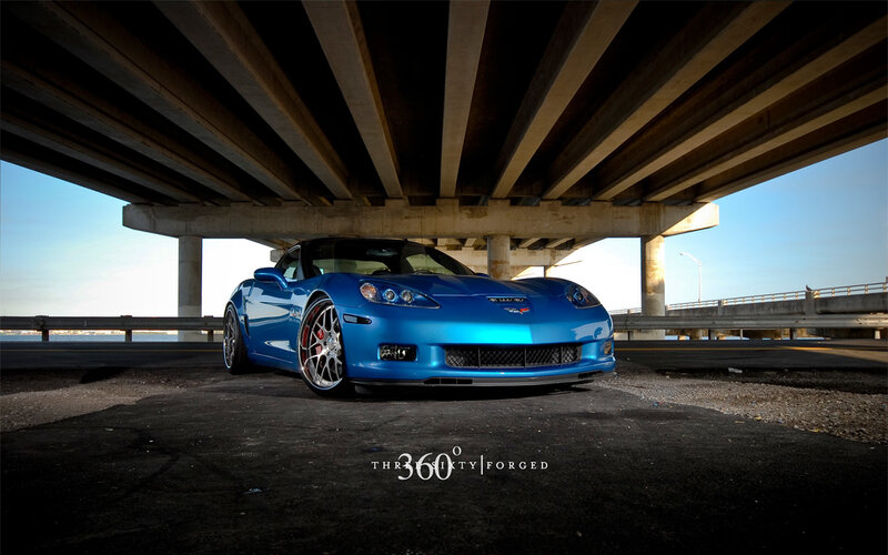 Blue Corvette under bridge
