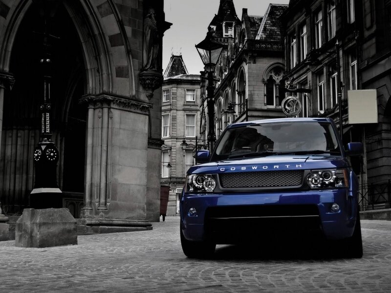 Blue Cosworth SUV on cobblestone street