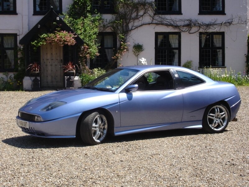 blue coupe parked in front of house
