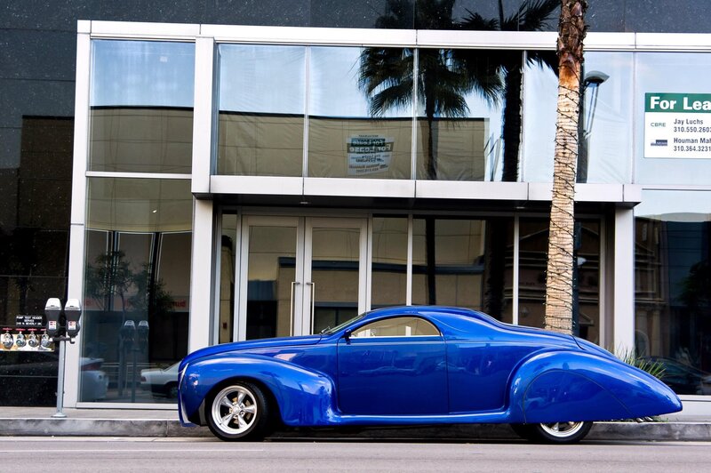 Blue custom car on city street