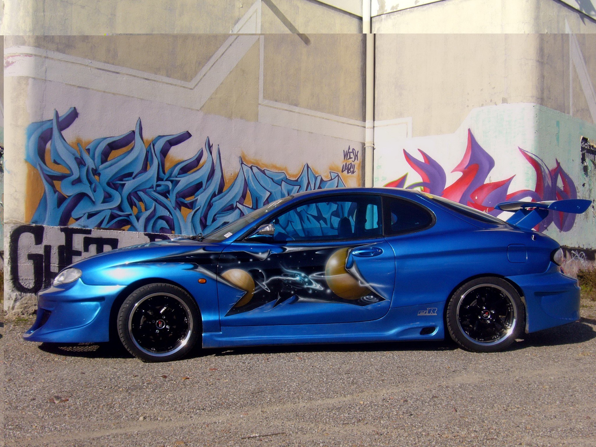 Blue custom car with graffiti art