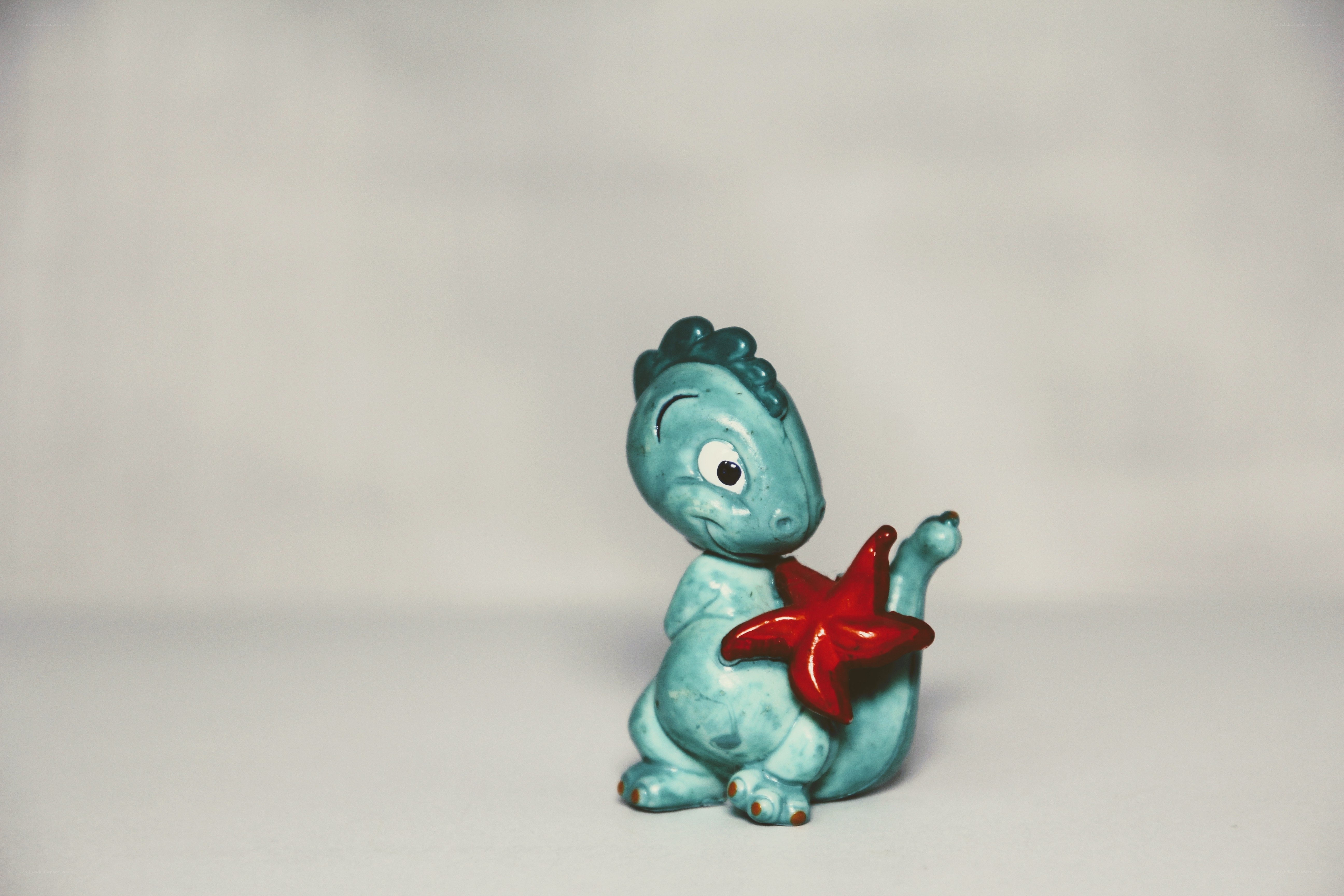 Blue dinosaur holding starfish