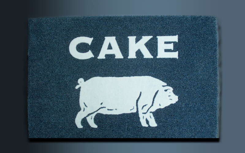 blue doormat with cake and pig
