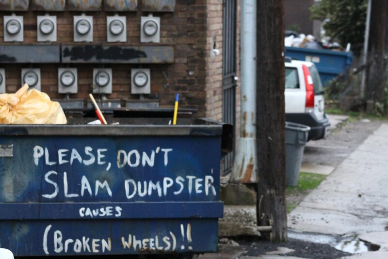 blue dumpster with graffiti