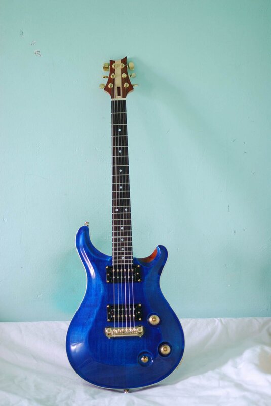 blue electric guitar on white cloth