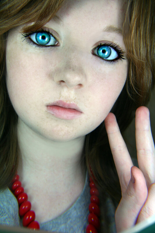blue-eyed girl with red beads