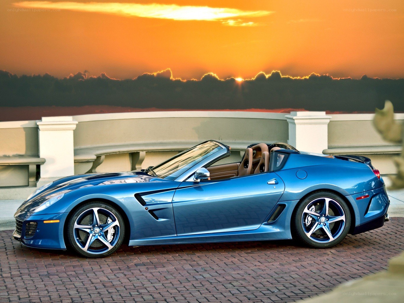 Blue Ferrari convertible at sunset