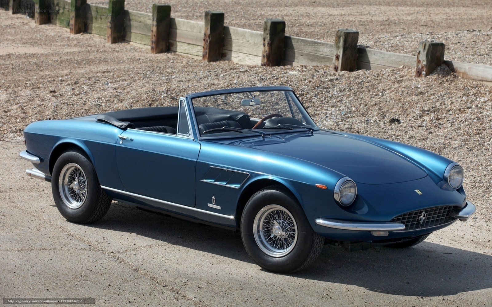 Blue Ferrari convertible on beach