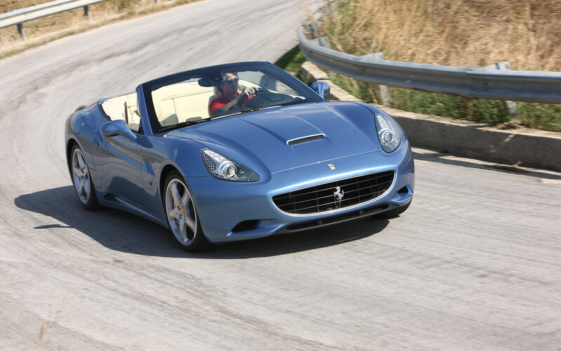 blue ferrari convertible on road