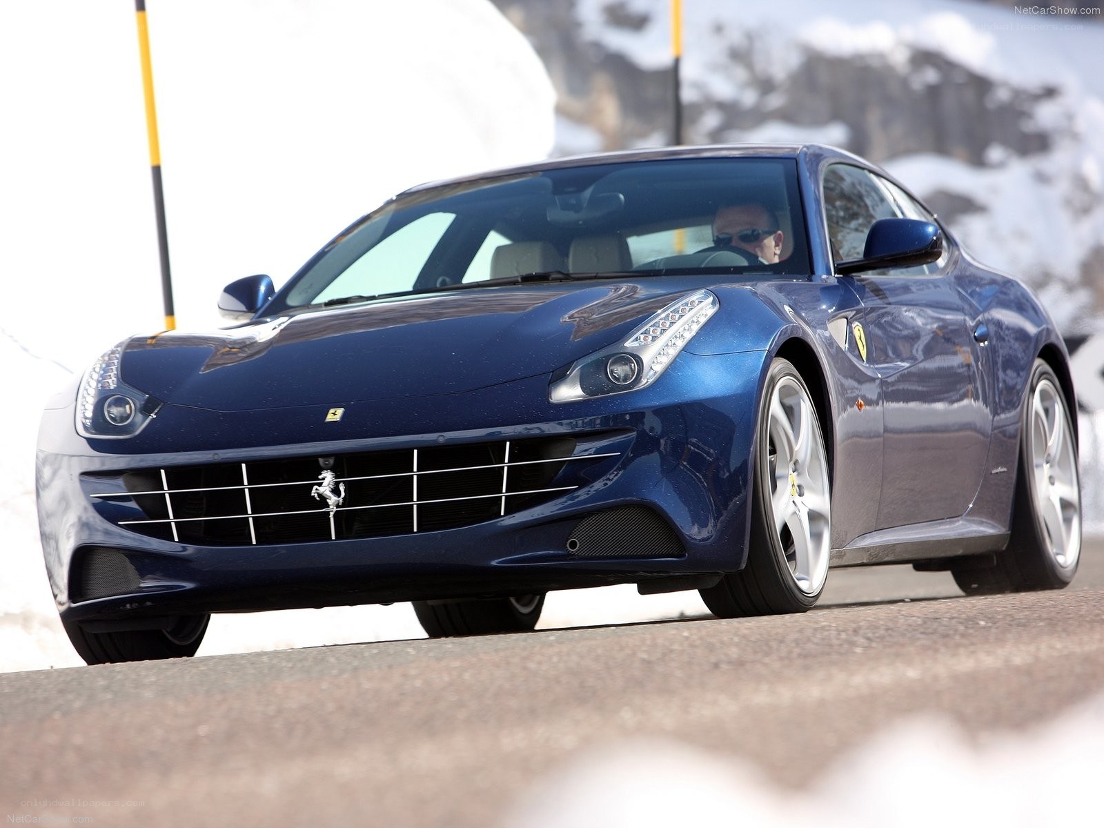 blue ferrari driving on mountain road