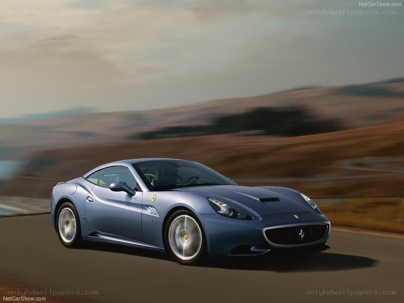 blue ferrari driving on road