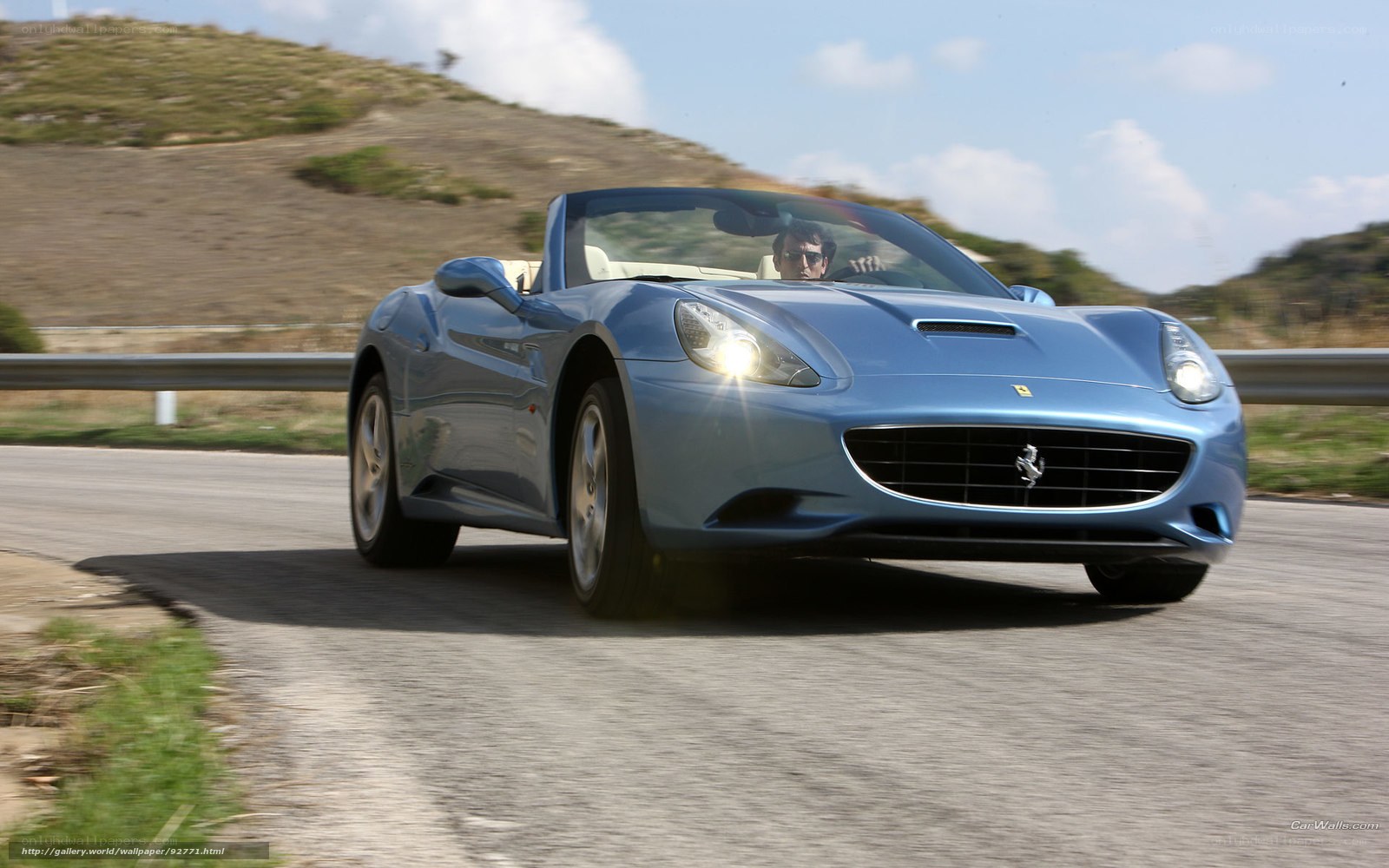 blue ferrari driving on road