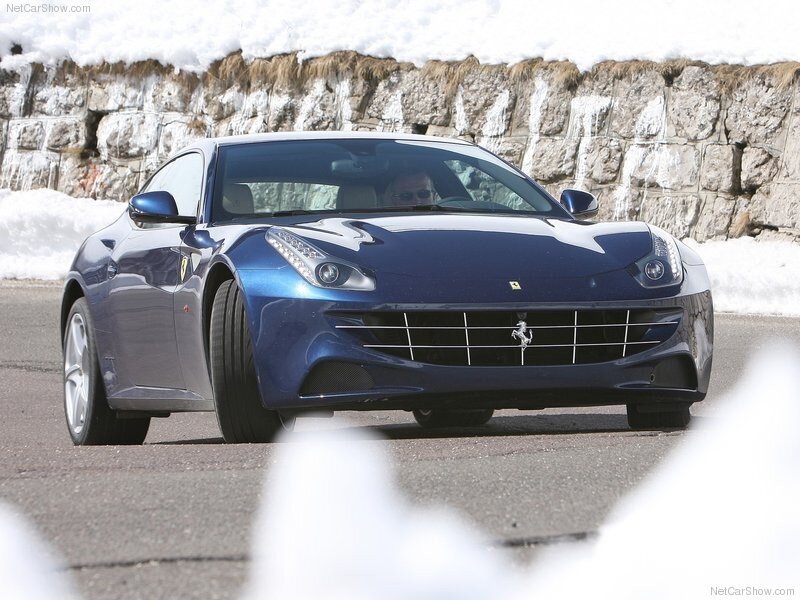 blue ferrari driving on snowy road