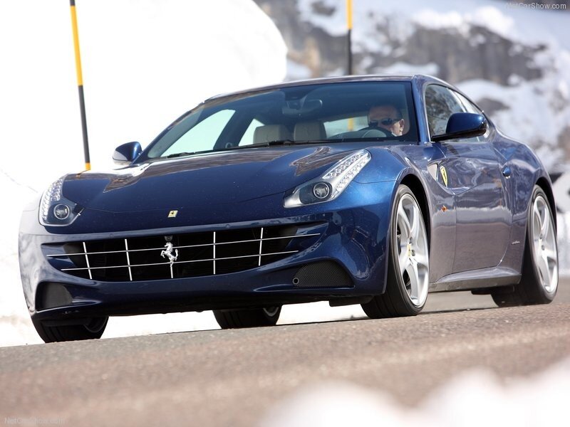 blue ferrari driving on snowy road