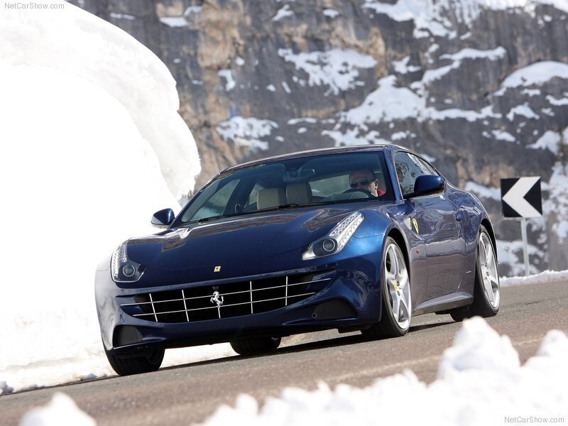 blue ferrari driving on snowy road