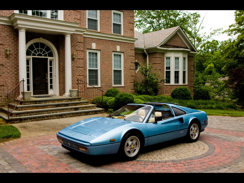 Blue Ferrari in front of brick house