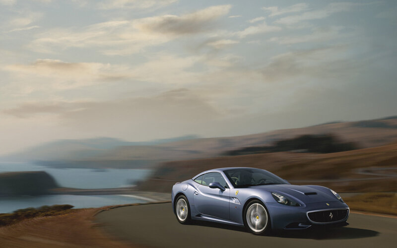 Blue Ferrari on coastal road