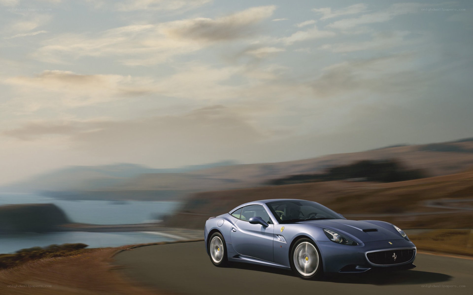 Blue Ferrari on coastal road