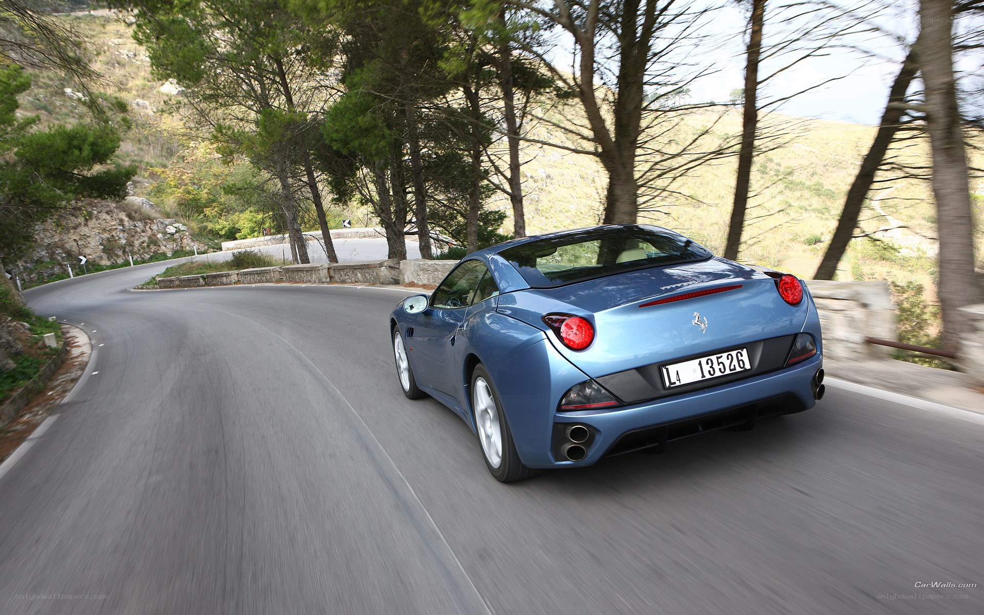 Blue Ferrari on winding road