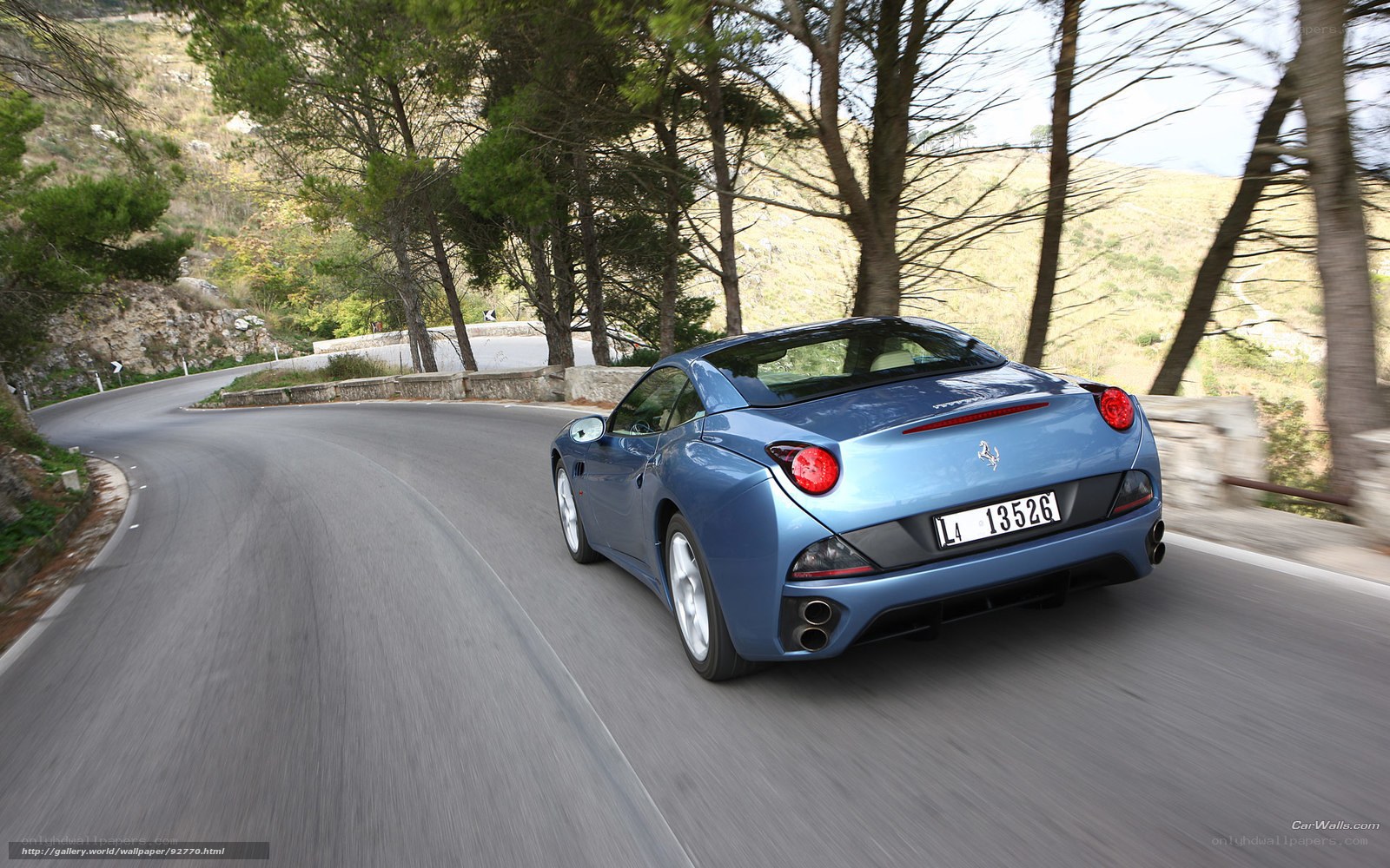 blue ferrari on winding road