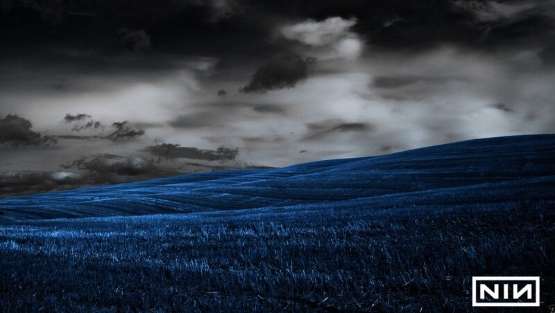 Blue field under stormy sky