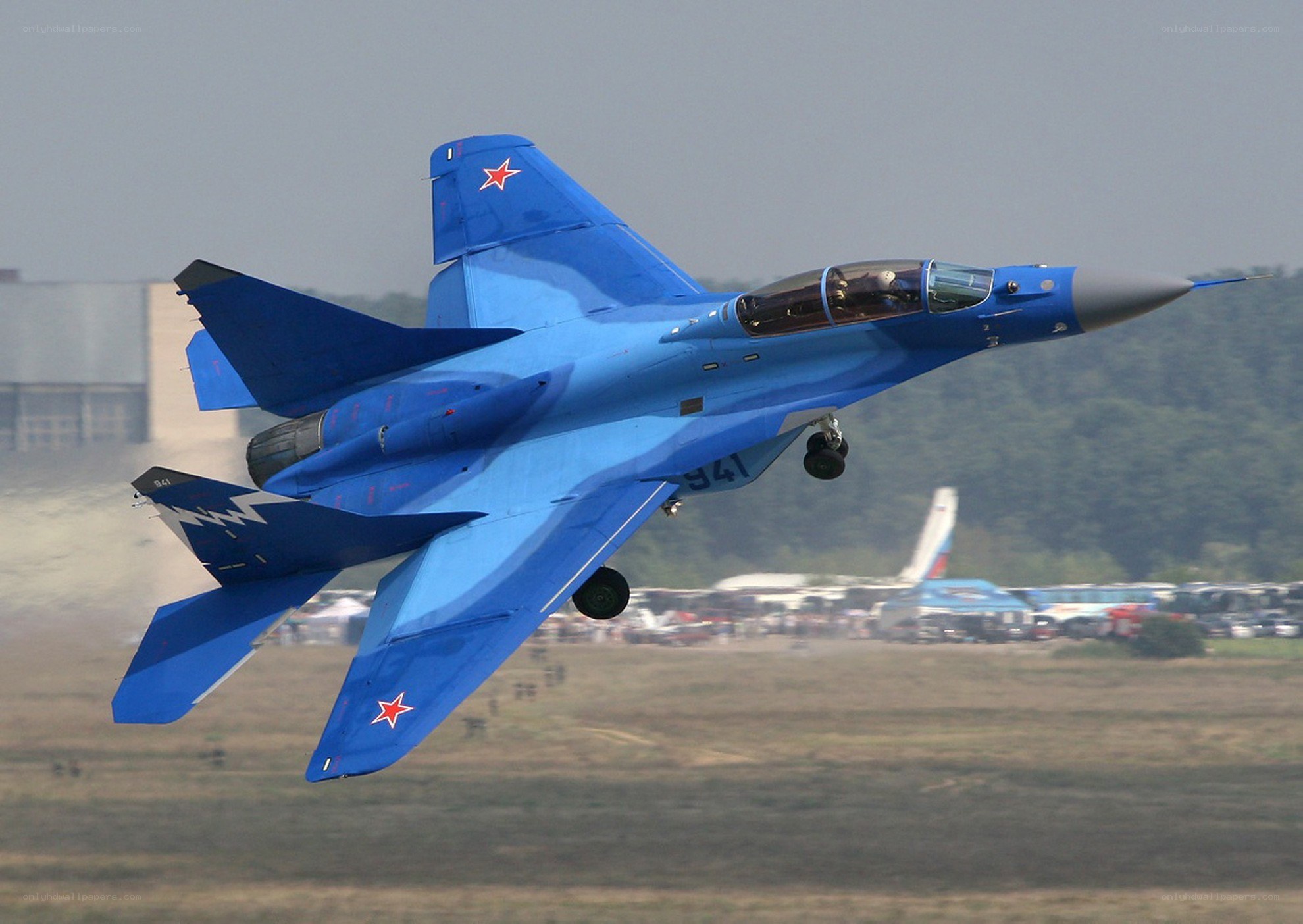 Blue fighter jet in flight