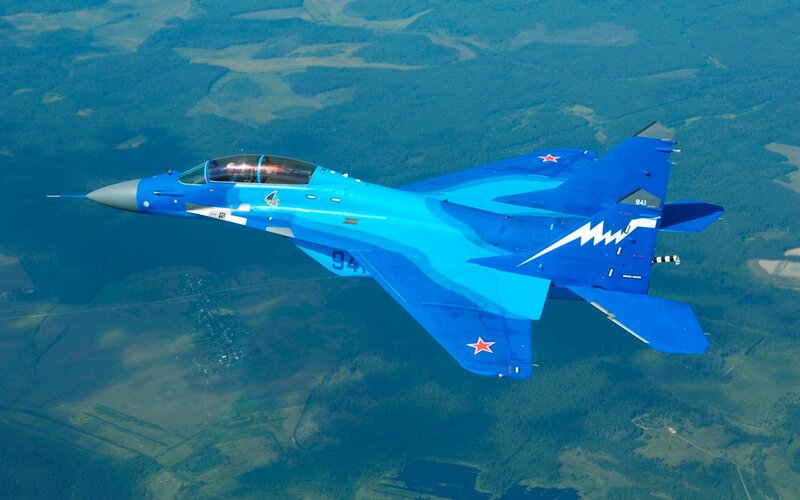Blue fighter jet in flight