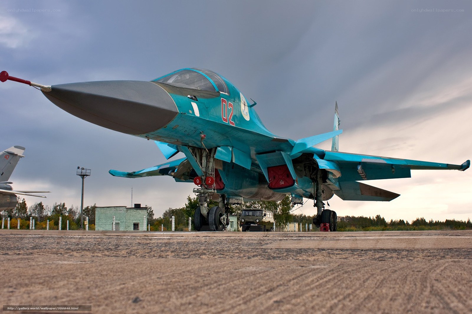 Blue fighter jet on tarmac