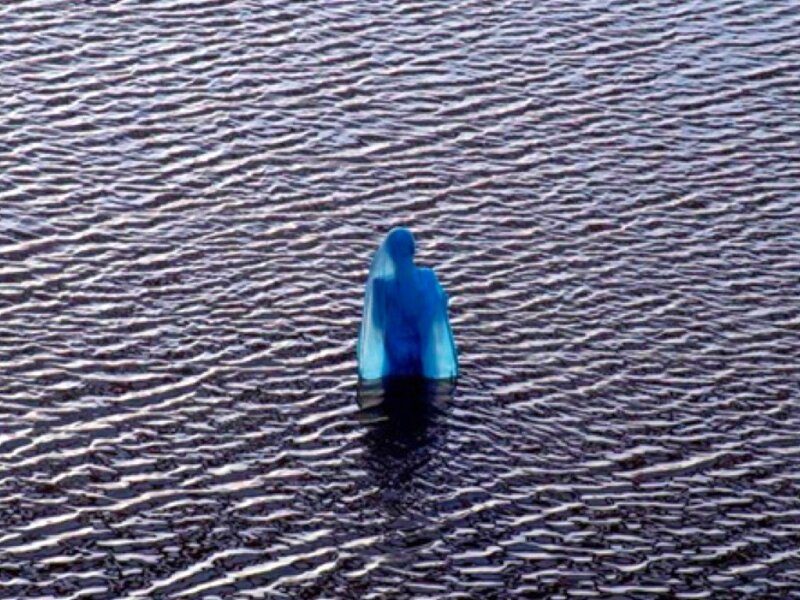 blue figure in rippling water