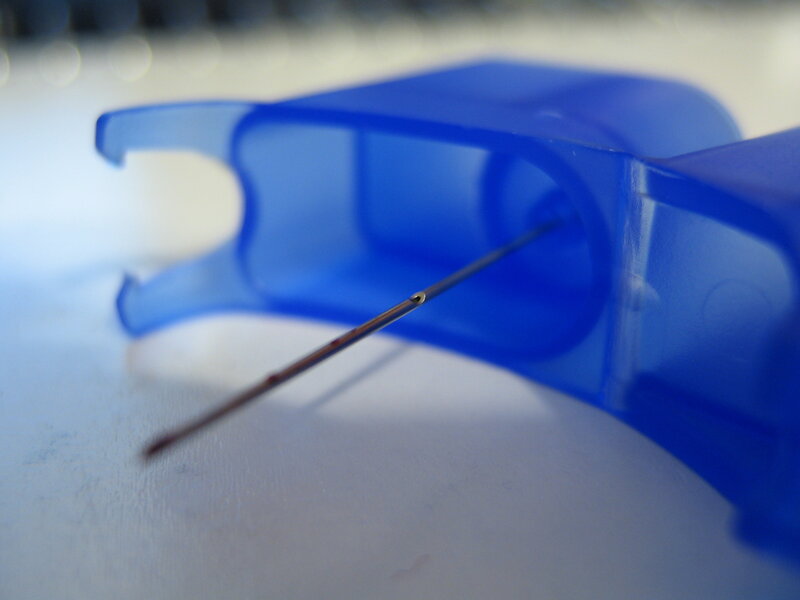 blue floss container with needle