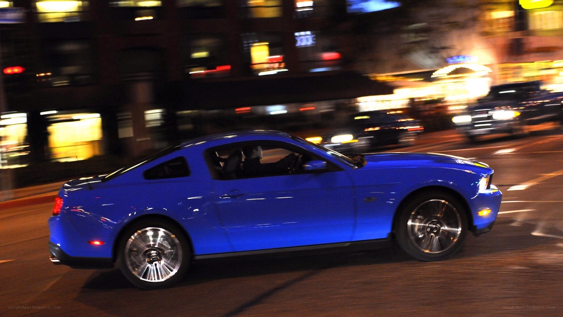Blue Ford Mustang driving at night