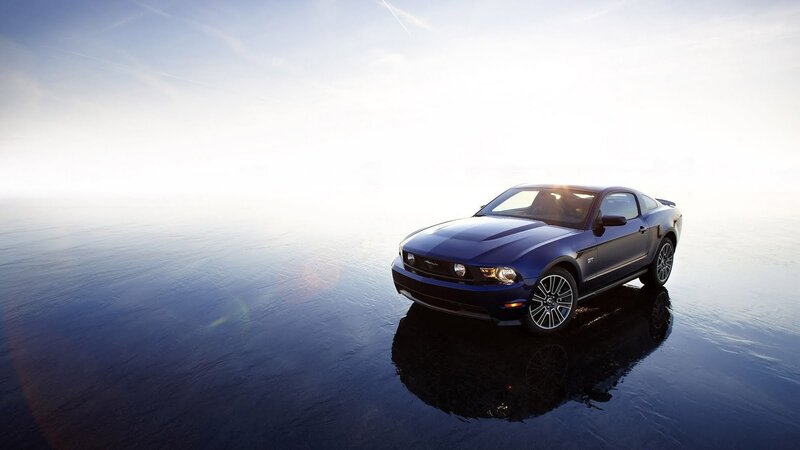 Blue Ford Mustang GT on wet surface
