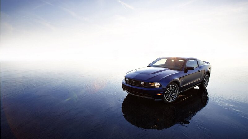 Blue Ford Mustang GT on wet surface