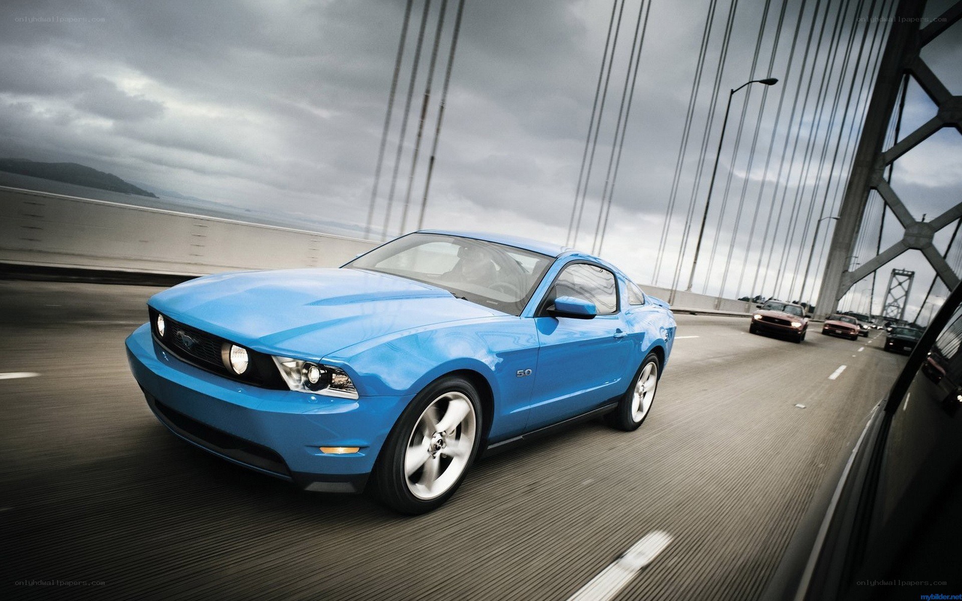 Blue Ford Mustang on a bridge
