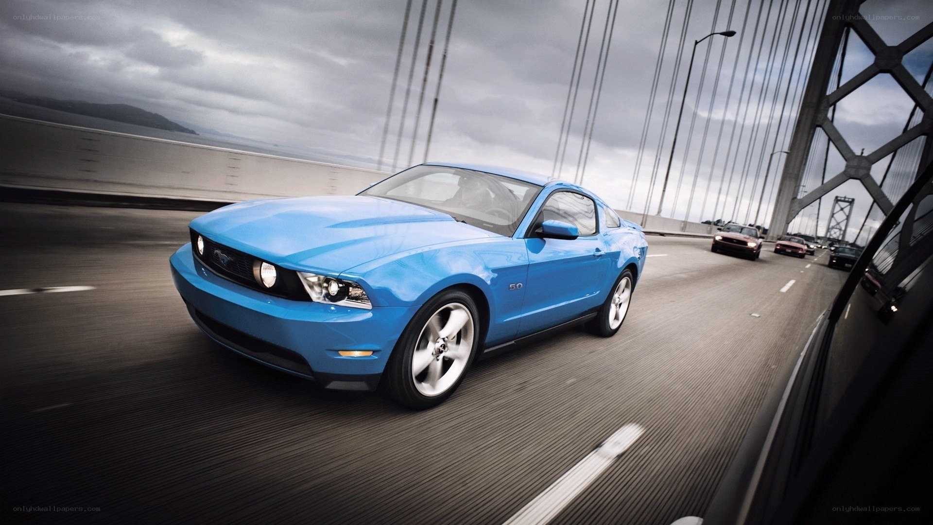 Blue Ford Mustang on a bridge