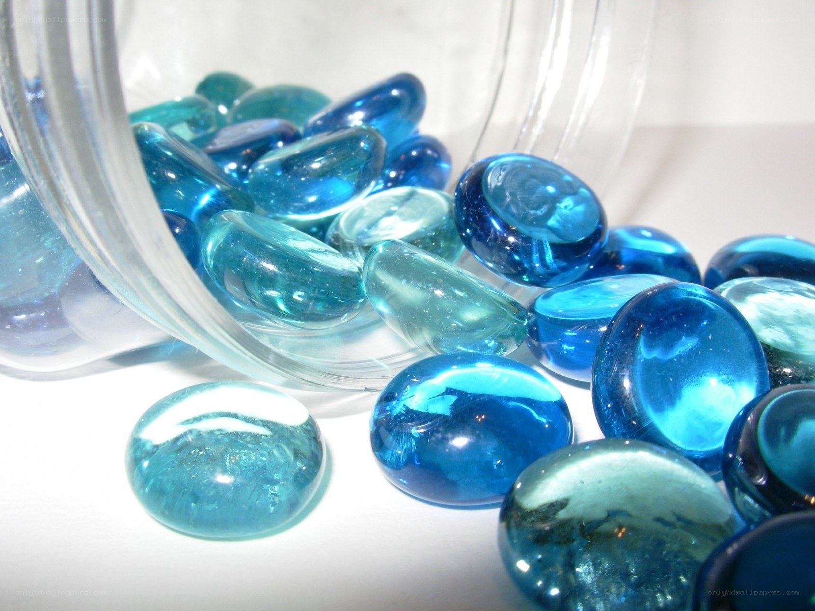 Blue glass beads spilling from a jar