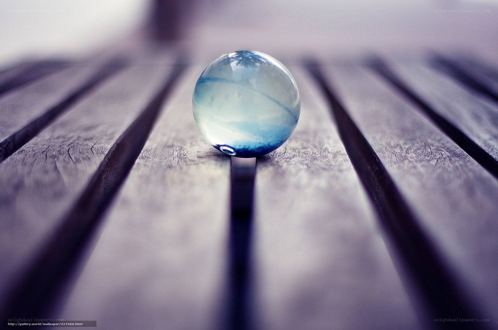 Blue glass marble on wood