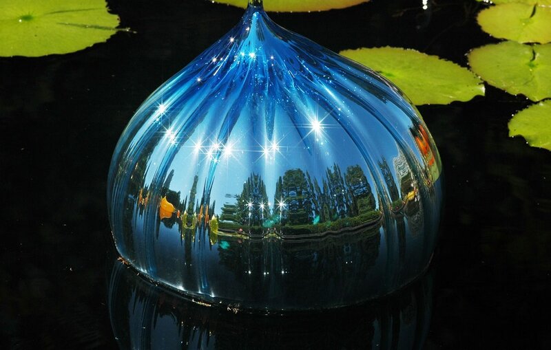 Blue glass sculpture in pond