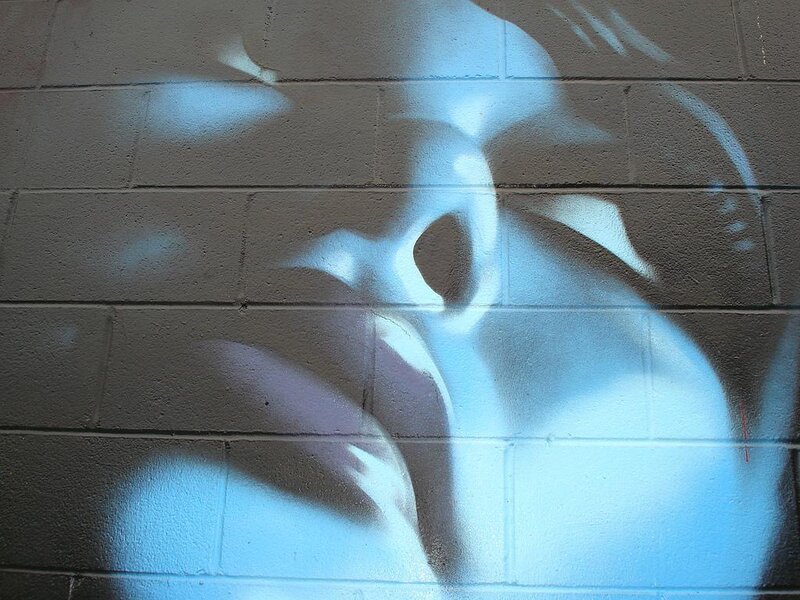 blue graffiti on brick wall