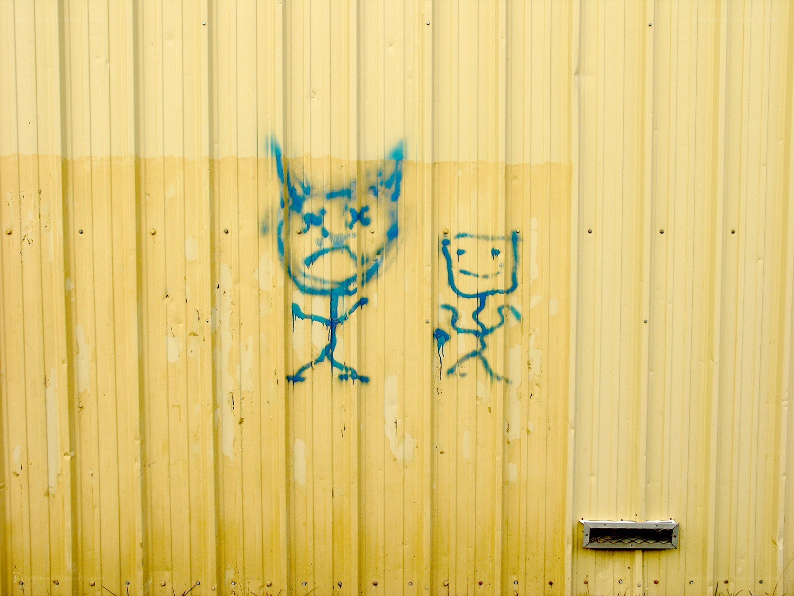 Blue graffiti on yellow wall