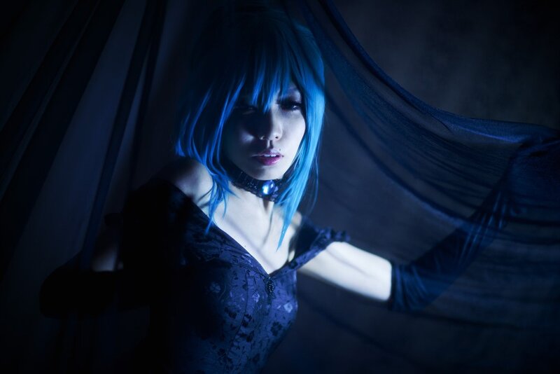 blue-haired cosplayer in dark setting