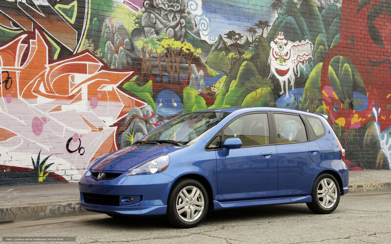 Blue Honda Fit in front of graffiti wall