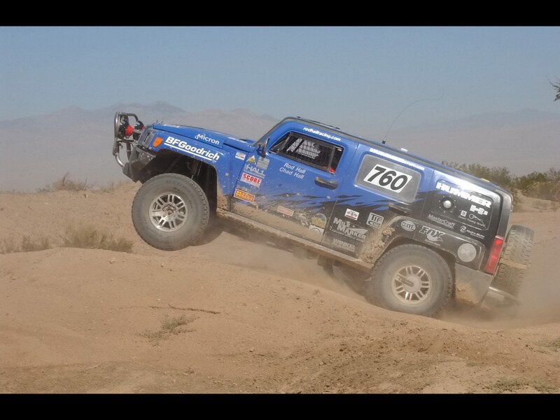 Blue Hummer racing on dirt