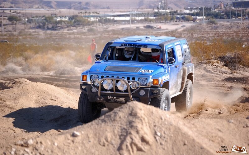 Blue Hummer racing on dirt track