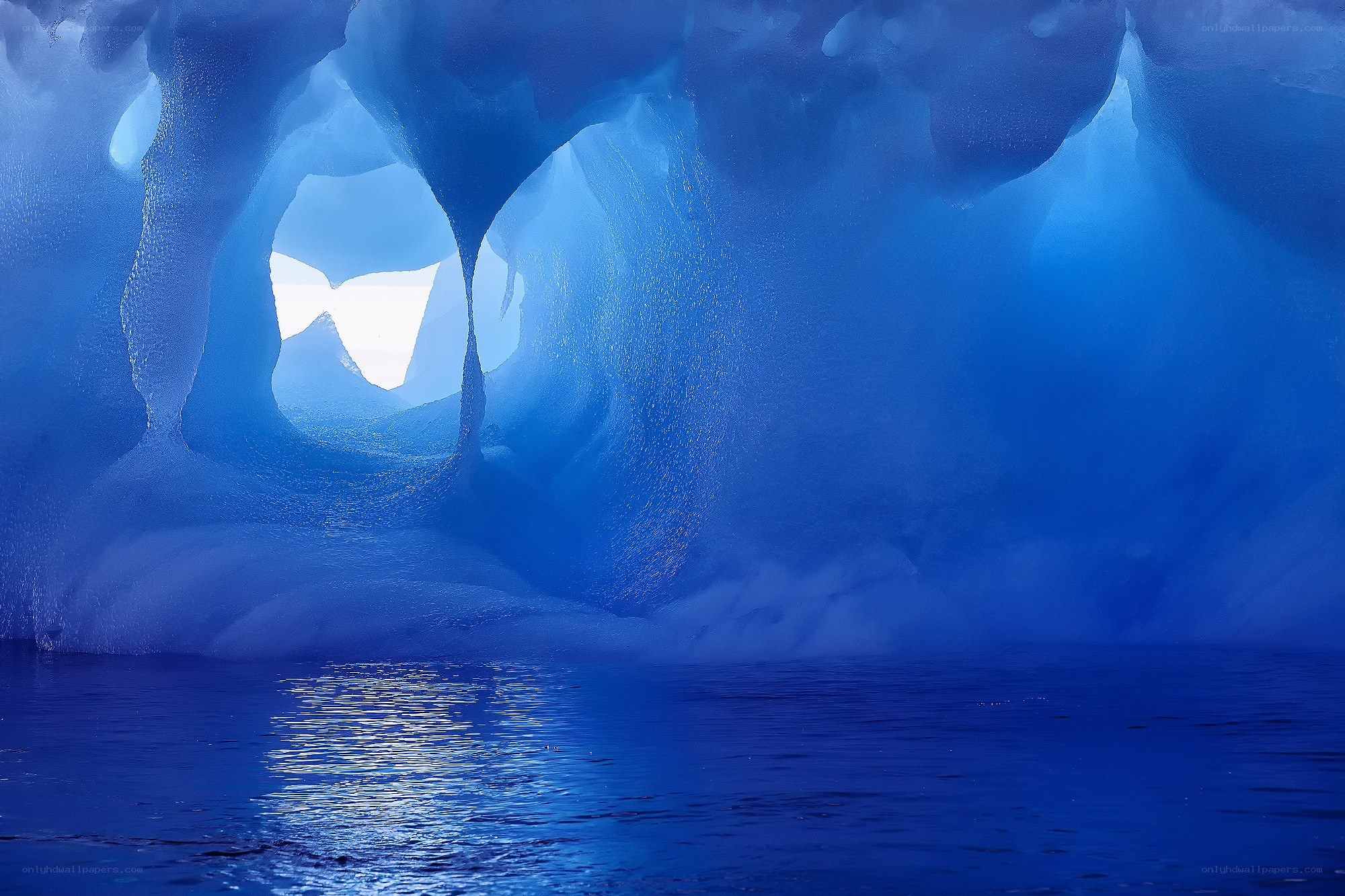 Blue ice cave with water reflection