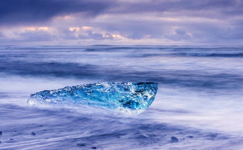 Blue Ice Chunk on Beach — Dramatic, Sunset