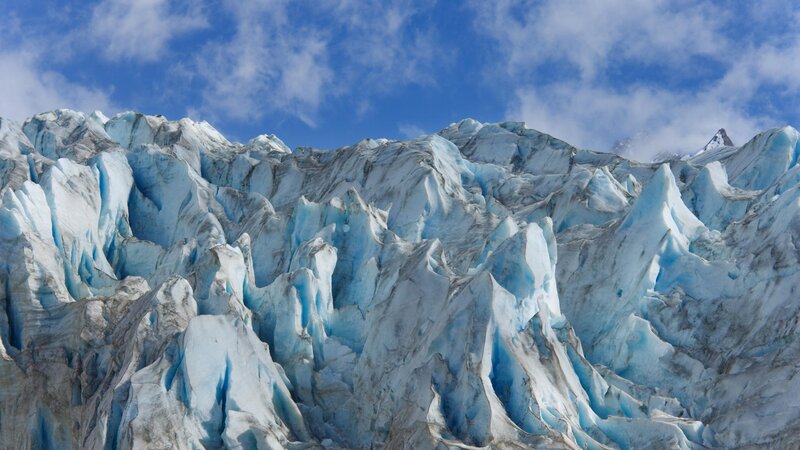 Blue ice glacier under cloudy sky
