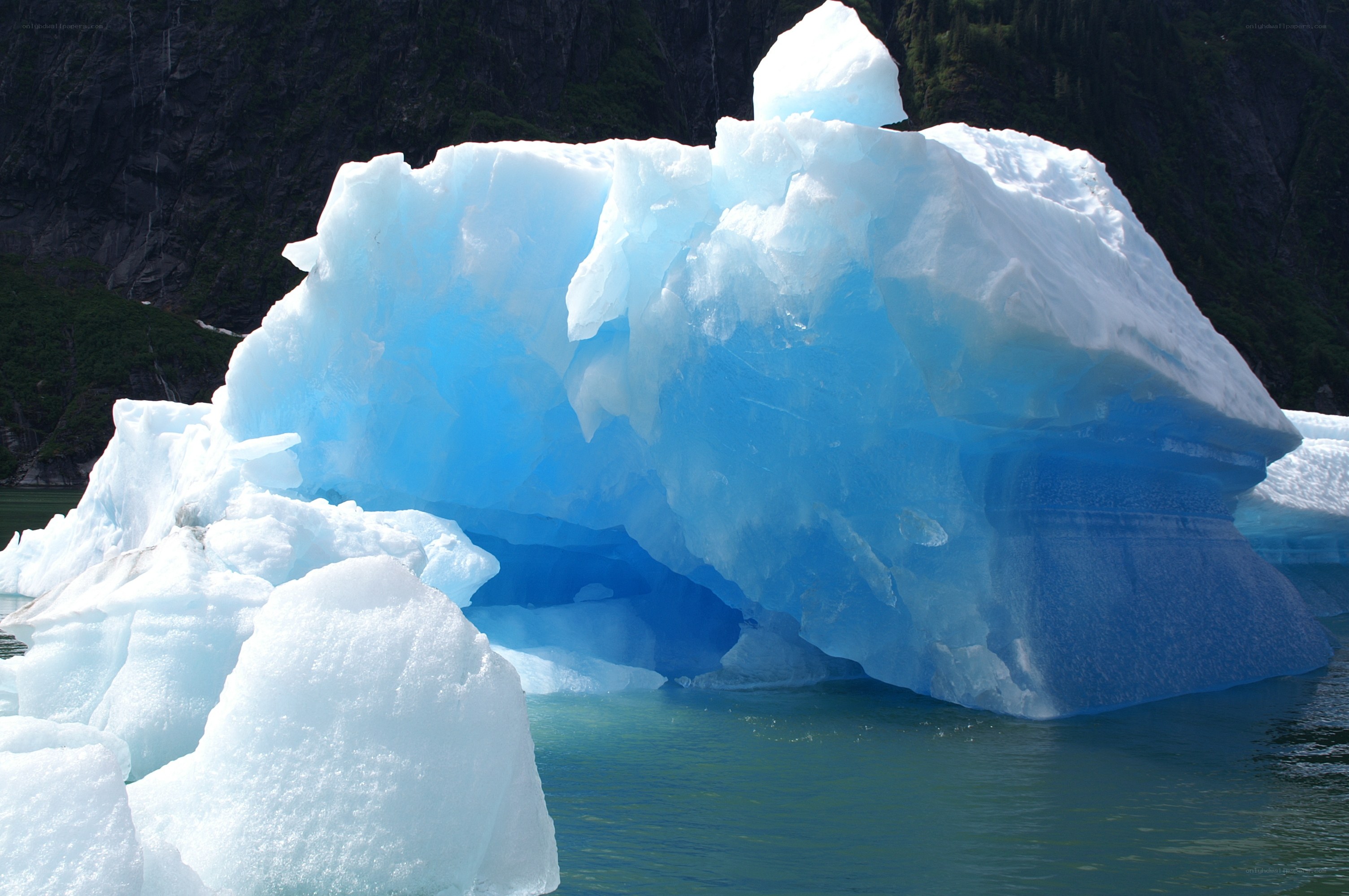 Blue iceberg floating in water