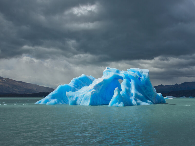 Blue iceberg in calm water